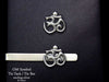 Om tie tack or tie bar shown on tie (front view)