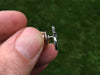 Om tie tack in hand side view